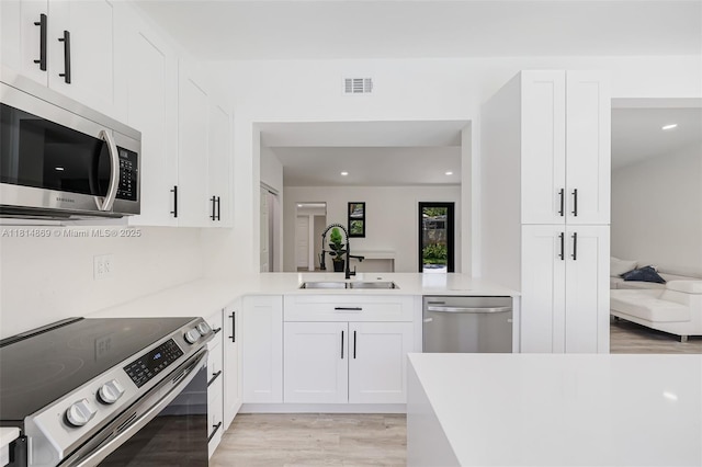 3105 SW 16th St, Fort Lauderdale, FL 33312 - kitchen with stainless steel appliances, a sink, light wood-type flooring, light countertops, and white cabinets