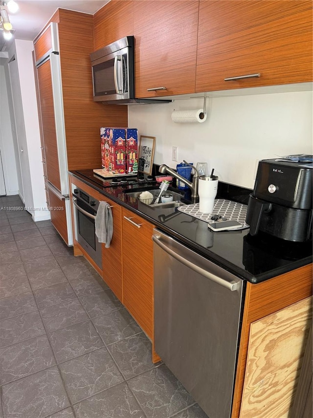 50 Biscayne Blvd Unit 3303, Miami, FL 33132 - kitchen with appliances with stainless steel finishes, a sink, dark countertops, and brown cabinets