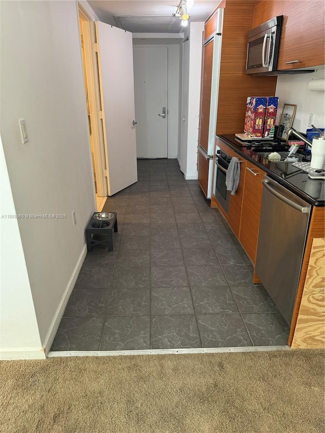 50 Biscayne Blvd Unit 3303, Miami, FL 33132 - kitchen featuring stainless steel appliances, a sink, dark countertops, brown cabinets, and modern cabinets