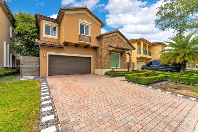 22618 SW 94th Path, Cutler Bay, FL 33190 - mediterranean / spanish house featuring a tiled roof, an attached garage, stucco siding, decorative driveway, and stone siding