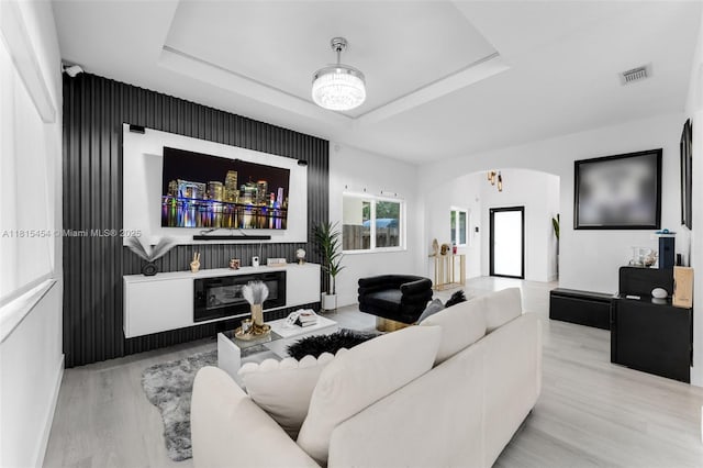 22618 SW 94th Path, Cutler Bay, FL 33190 - living room with arched walkways, wood finished floors, a tray ceiling, and baseboards