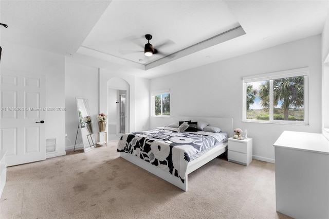 22618 SW 94th Path, Cutler Bay, FL 33190 - bedroom with light carpet, a raised ceiling, baseboards, arched walkways, and ceiling fan