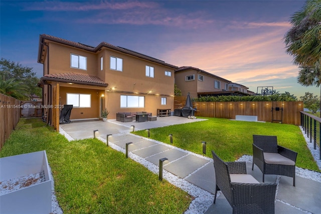 22618 SW 94th Path, Cutler Bay, FL 33190 - back of house at dusk with a tiled roof, stucco siding, a patio area, and an outdoor living space
