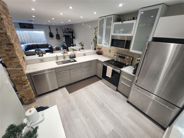 10875 NW 8th St, Pembroke Pines, FL 33026 - kitchen featuring stainless steel appliances, a sink, modern cabinets, light countertops, and light wood-type flooring