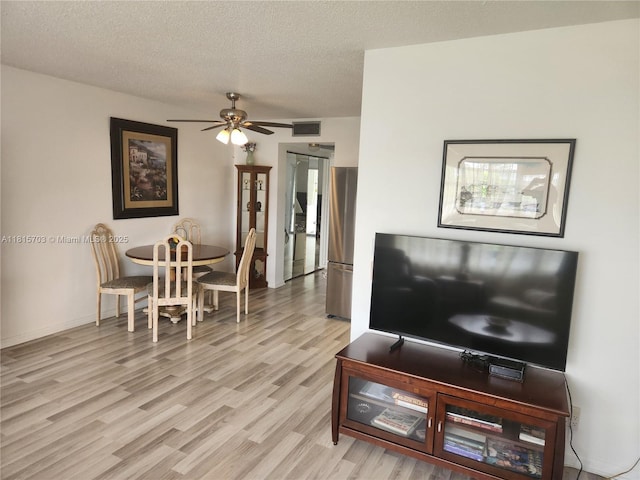 4144 Cambridge G 4144, Deerfield Beach, FL 33442 - living room featuring light wood finished floors, ceiling fan, and a textured ceiling