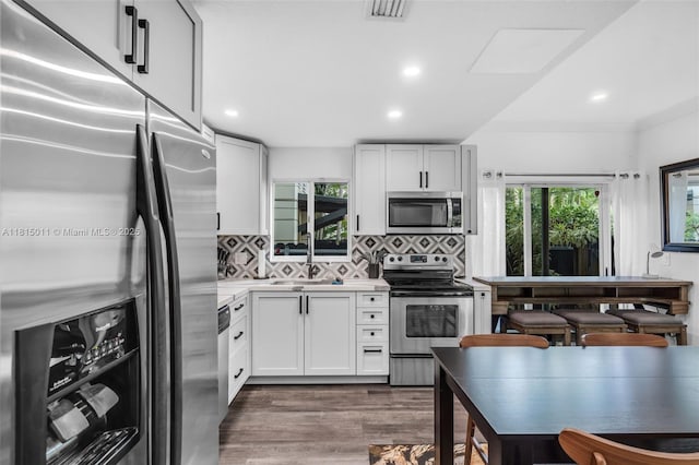 3145 Day Ave Unit 1, Miami, FL 33133 - kitchen with appliances with stainless steel finishes, dark wood-style flooring, light countertops, tasteful backsplash, and a sink
