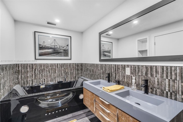 3145 Day Ave Unit 1, Miami, FL 33133 - bathroom with double vanity, backsplash, recessed lighting, and wood finished floors