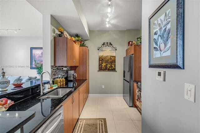 2775 NE 187th St Unit Ph6, Aventura, FL 33180 - kitchen with track lighting, a sink, stainless steel appliances, brown cabinets, and dark stone counters