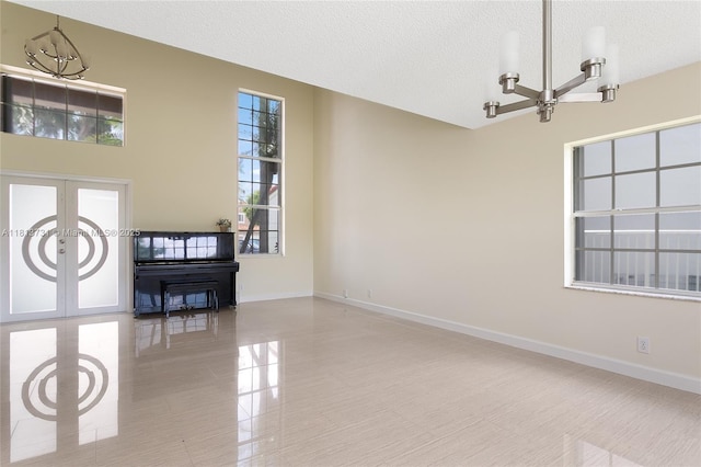 210 Somerset Way, Weston, FL 33326 - unfurnished living room with french doors, a chandelier, a textured ceiling, baseboards, and light tile patterned floors