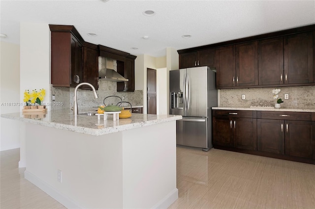 210 Somerset Way, Weston, FL 33326 - kitchen with stainless steel fridge, wall chimney exhaust hood, light stone counters, decorative backsplash, and dark brown cabinetry