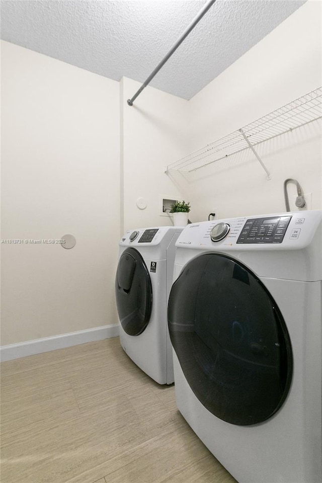 210 Somerset Way, Weston, FL 33326 - washroom featuring washing machine and clothes dryer, baseboards, and a textured ceiling