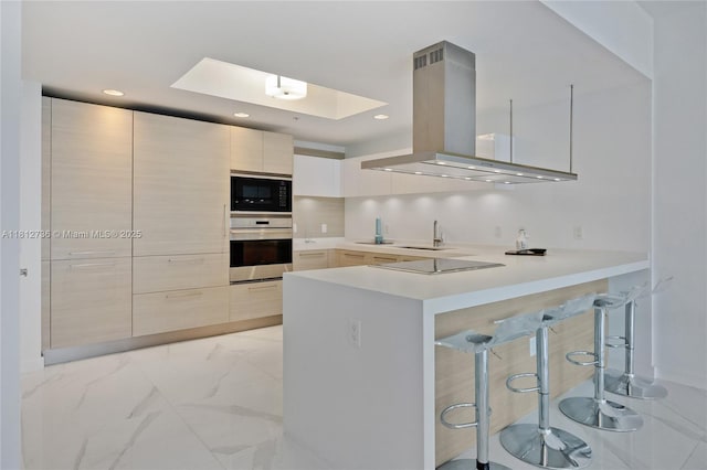 17301 Biscayne Blvd Unit 605, North Miami Beach, FL 33160 - kitchen with island exhaust hood, black appliances, modern cabinets, light countertops, and a breakfast bar