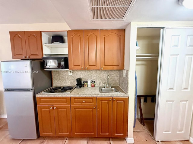 19201 Collins Ave Unit 1019, Sunny Isles Beach, FL 33160 - kitchen with black microwave, freestanding refrigerator, a sink, electric cooktop, and light countertops