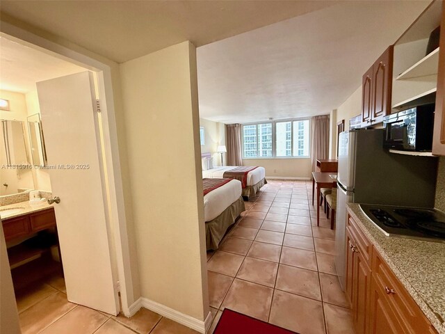 19201 Collins Ave Unit 1019, Sunny Isles Beach, FL 33160 - bedroom with light tile patterned floors, baseboards, and connected bathroom