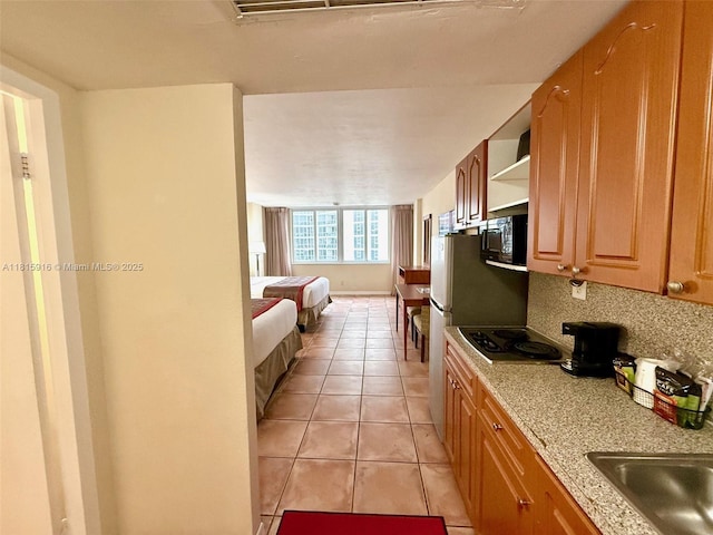 19201 Collins Ave Unit 1019, Sunny Isles Beach, FL 33160 - kitchen featuring light countertops, electric stovetop, light tile patterned floors, open floor plan, and decorative backsplash