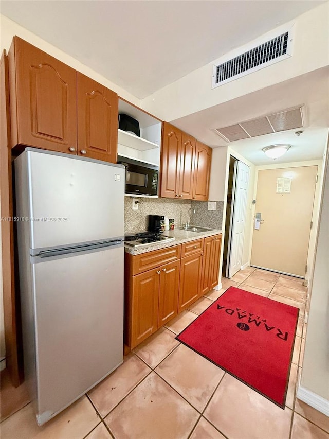 19201 Collins Ave Unit 1019, Sunny Isles Beach, FL 33160 - kitchen with freestanding refrigerator, black microwave, electric cooktop, tasteful backsplash, and light countertops
