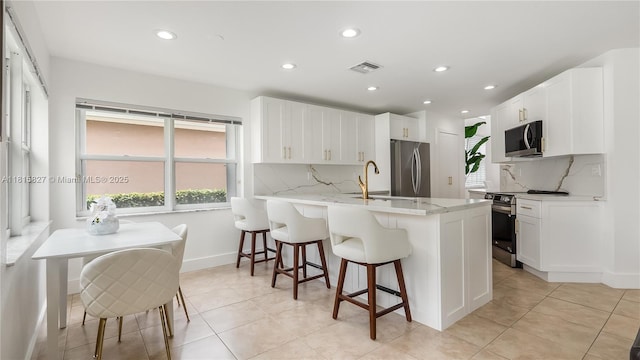 1981 NW 171st Ave, Pembroke Pines, FL 33028 - kitchen featuring appliances with stainless steel finishes, a peninsula, a kitchen bar, recessed lighting, and tasteful backsplash