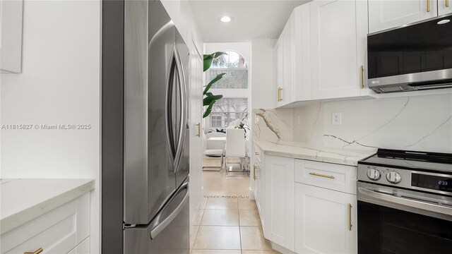1981 NW 171st Ave, Pembroke Pines, FL 33028 - kitchen featuring appliances with stainless steel finishes, light stone countertops, white cabinetry, light tile patterned floors, and recessed lighting