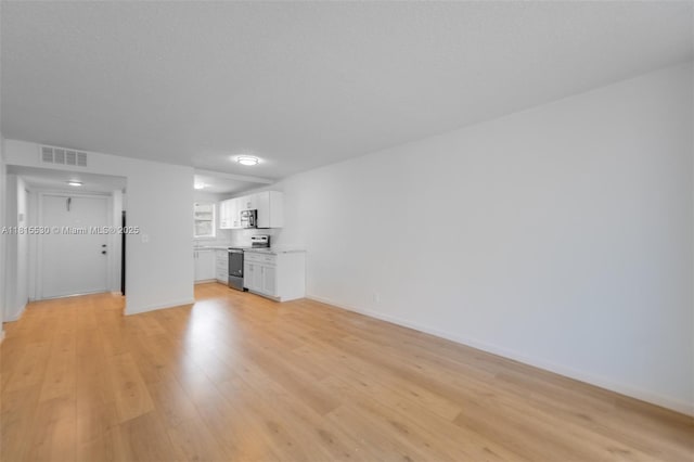 9601 Sunrise Lakes Blvd Unit 106, Sunrise, FL 33322 - unfurnished living room featuring light wood-style flooring and baseboards