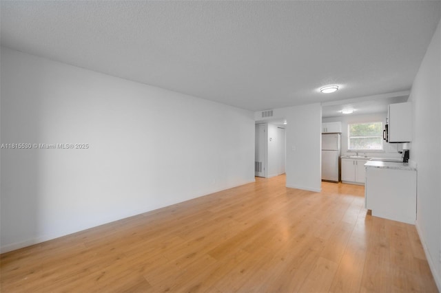 9601 Sunrise Lakes Blvd Unit 106, Sunrise, FL 33322 - unfurnished living room featuring light wood-style flooring