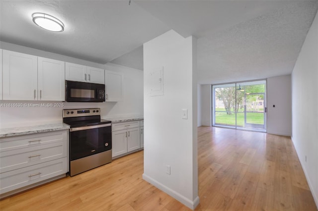 9601 Sunrise Lakes Blvd Unit 106, Sunrise, FL 33322 - kitchen featuring black microwave, stainless steel electric stove, light wood-type flooring, white cabinetry, and baseboards
