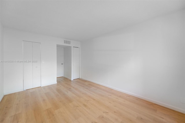 9601 Sunrise Lakes Blvd Unit 106, Sunrise, FL 33322 - unfurnished bedroom featuring light wood finished floors, baseboards, and multiple closets