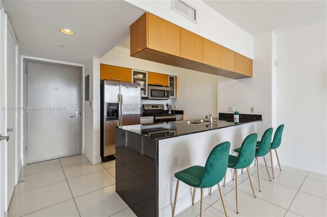 1750 N Bayshore Dr Unit 4604, Miami, FL 33132 - kitchen with stainless steel appliances, a peninsula, a kitchen breakfast bar, dark countertops, and glass insert cabinets