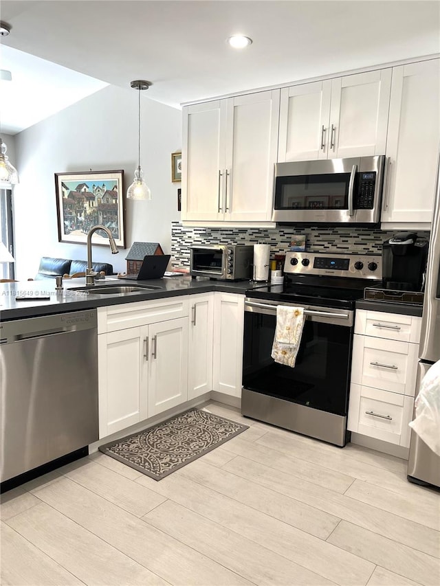 10830 SW 72nd St Unit 14, Miami, FL 33173 - kitchen featuring stainless steel appliances, a sink, dark countertops, light wood-style floors, and recessed lighting