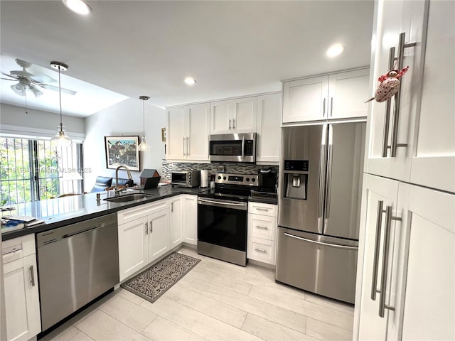 10830 SW 72nd St Unit 14, Miami, FL 33173 - kitchen featuring appliances with stainless steel finishes, a sink, dark countertops, a ceiling fan, and decorative backsplash