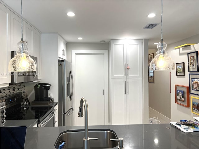 10830 SW 72nd St Unit 14, Miami, FL 33173 - kitchen featuring stainless steel appliances, a sink, dark countertops, white cabinets, and recessed lighting