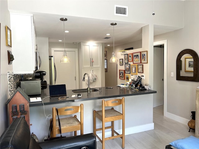 10830 SW 72nd St Unit 14, Miami, FL 33173 - kitchen with a sink, a peninsula, dark countertops, appliances with stainless steel finishes, and white cabinetry