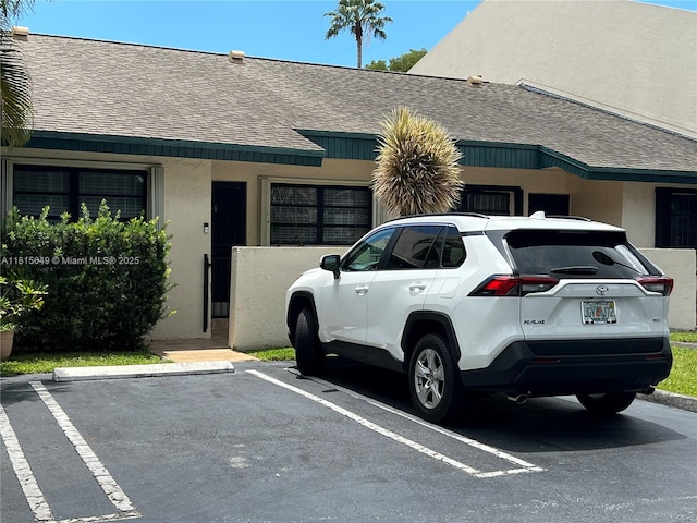 10830 SW 72nd St Unit 14, Miami, FL 33173 - view of home's exterior featuring roof with shingles, uncovered parking, and stucco siding