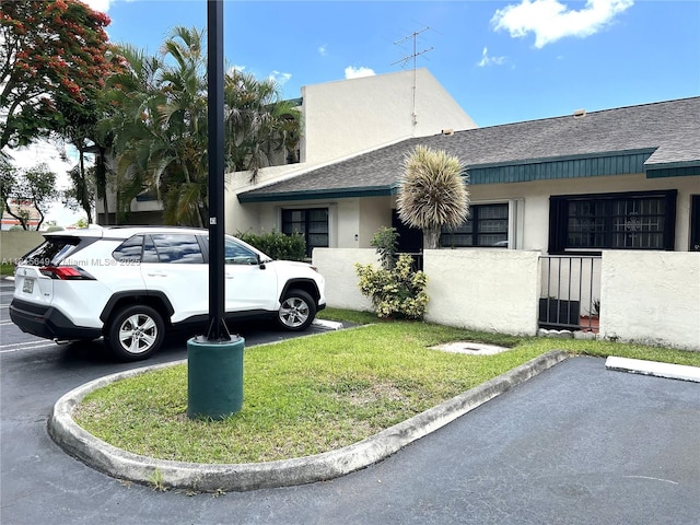 10830 SW 72nd St Unit 14, Miami, FL 33173 - view of home's exterior featuring uncovered parking, a shingled roof, and stucco siding