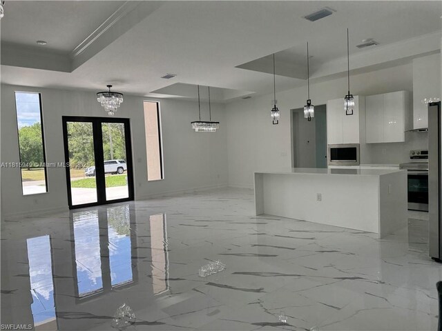 1016 Magnolia Ave, Lehigh Acres, FL 33974 - kitchen with modern cabinets, a raised ceiling, appliances with stainless steel finishes, white cabinetry, and open floor plan