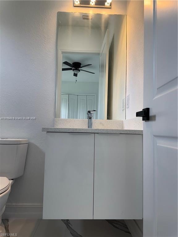 1016 Magnolia Ave, Lehigh Acres, FL 33974 - half bath featuring toilet, vanity, a ceiling fan, and baseboards