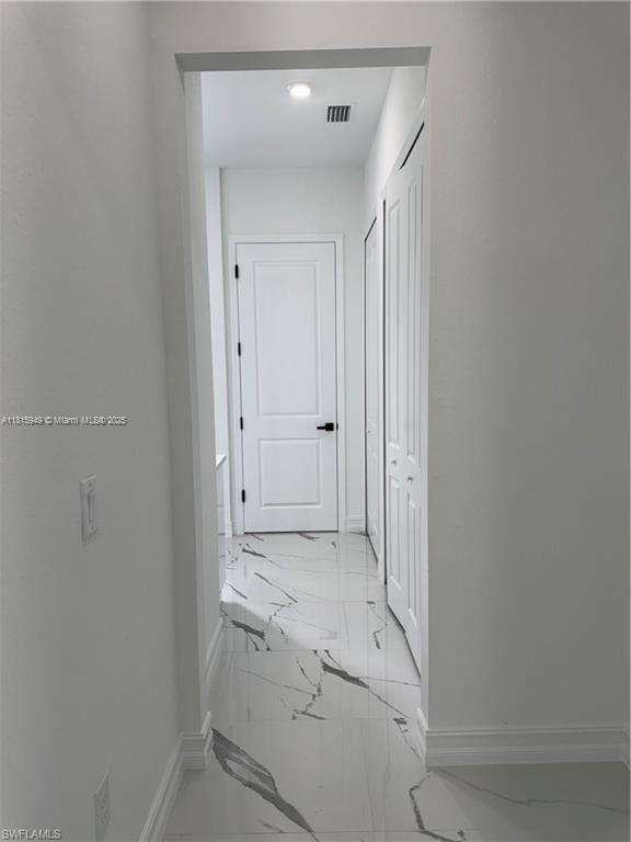 1016 Magnolia Ave, Lehigh Acres, FL 33974 - hallway featuring light marble finish flooring and baseboards