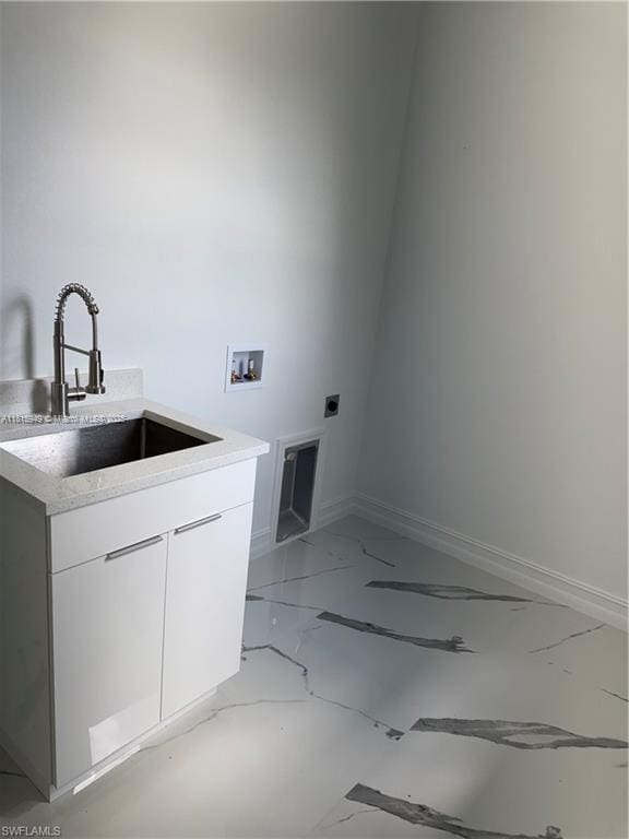 1016 Magnolia Ave, Lehigh Acres, FL 33974 - washroom featuring hookup for an electric dryer, cabinet space, washer hookup, light marble finish floors, and baseboards