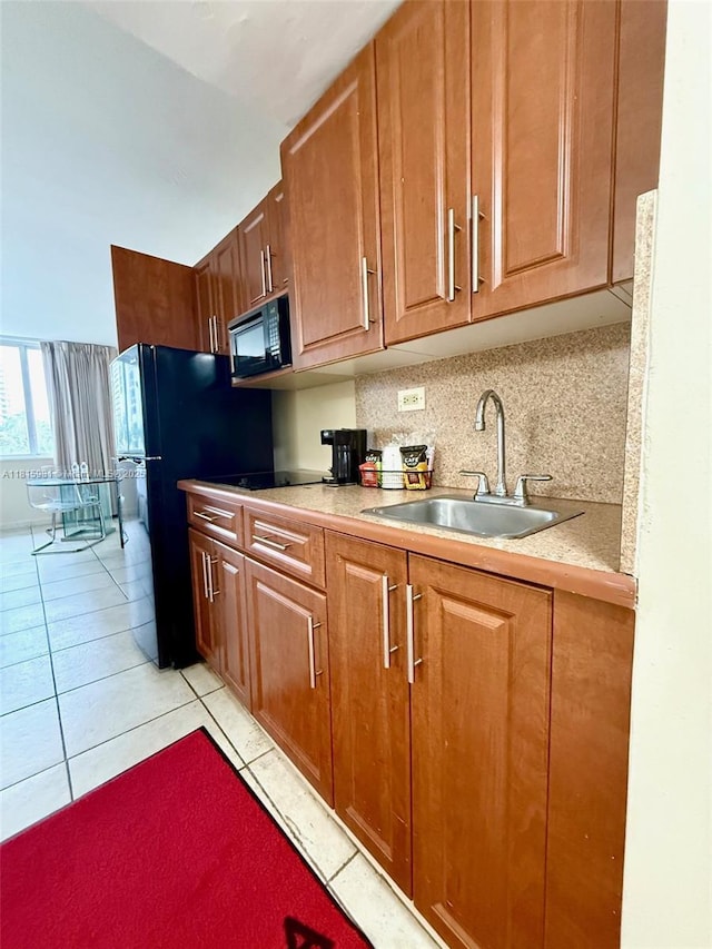 19201 Collins Ave Unit 242, Sunny Isles Beach, FL 33160 - kitchen featuring a sink, black microwave, light countertops, light tile patterned floors, and brown cabinets