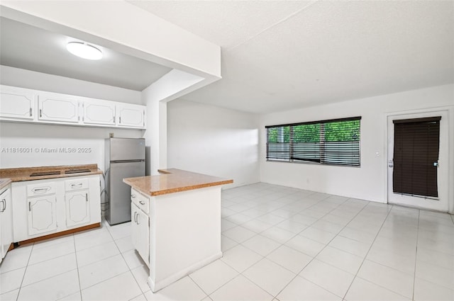 4007 Durham A 4007, Deerfield Beach, FL 33442 - kitchen featuring freestanding refrigerator, white cabinetry, a kitchen island, light tile patterned floors, and open floor plan