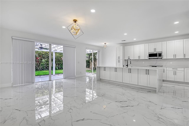 12173 Colony Preserve Dr, Boynton Beach, FL 33436 - kitchen with appliances with stainless steel finishes, recessed lighting, light marble finish flooring, white cabinets, and light countertops