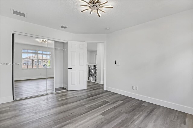 12173 Colony Preserve Dr, Boynton Beach, FL 33436 - unfurnished bedroom featuring a closet, wood finished floors, and a textured ceiling