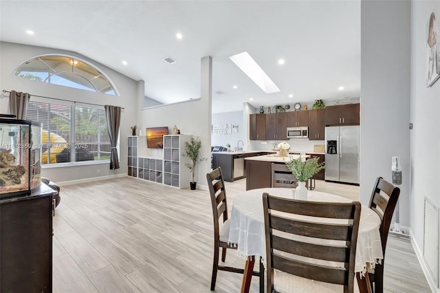 3059 Dogwood Ln, Margate, FL 33063 - dining room featuring vaulted ceiling, a skylight, baseboards, light wood-style floors, and recessed lighting