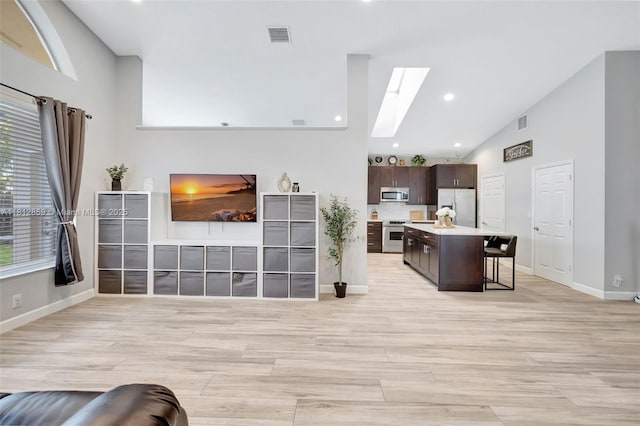 3059 Dogwood Ln, Margate, FL 33063 - living area with a skylight, baseboards, high vaulted ceiling, light wood-style flooring, and recessed lighting