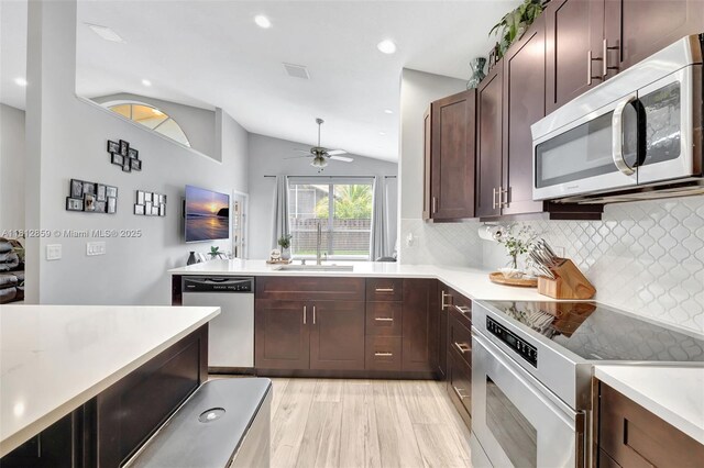 3059 Dogwood Ln, Margate, FL 33063 - kitchen with stainless steel appliances, vaulted ceiling, light countertops, a sink, and backsplash