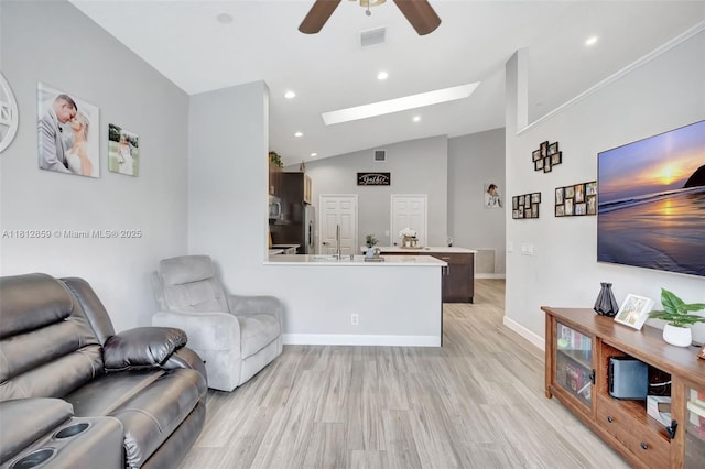 3059 Dogwood Ln, Margate, FL 33063 - living room with light wood-style floors, ceiling fan, vaulted ceiling, a skylight, and baseboards