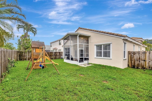 3059 Dogwood Ln, Margate, FL 33063 - rear view of property featuring a playground, a sunroom, stucco siding, and a tile roof