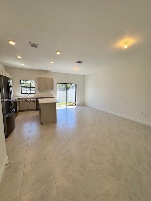 605 NW 6th Ter, Florida City, FL 33034 - kitchen with freestanding refrigerator, open floor plan, light tile patterned floors, recessed lighting, and light countertops