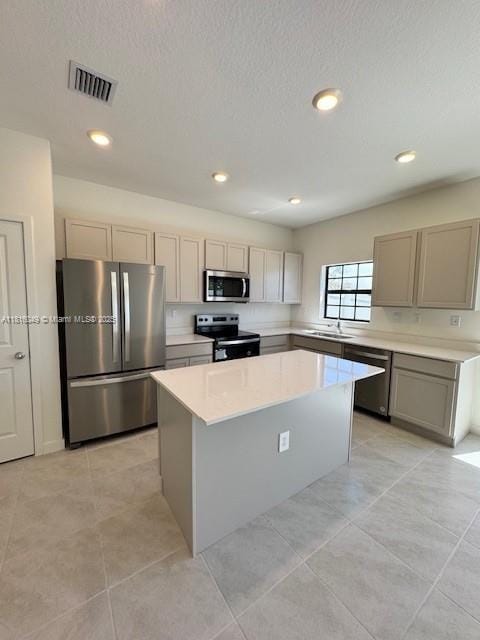 605 NW 6th Ter, Florida City, FL 33034 - kitchen with appliances with stainless steel finishes, a sink, a center island, light countertops, and gray cabinetry