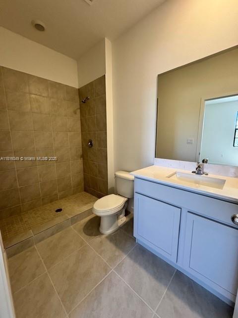 605 NW 6th Ter, Florida City, FL 33034 - full bathroom featuring vanity, a tile shower, tile patterned floors, and toilet