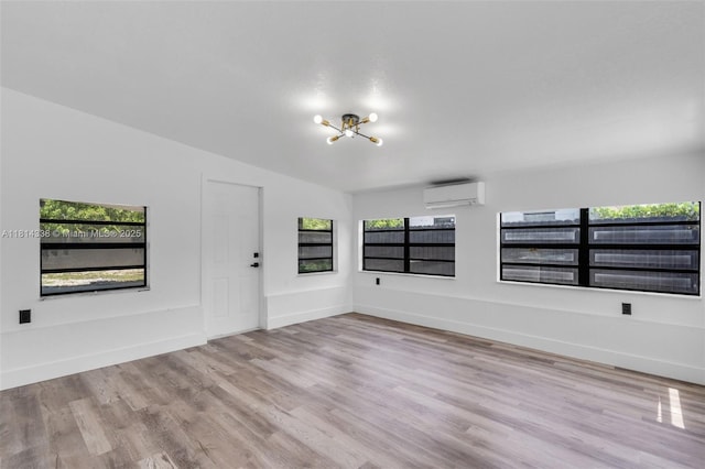 19330 NE 2nd Ave, Miami, FL 33179 - unfurnished room featuring a wall mounted air conditioner, a chandelier, wood finished floors, and healthy amount of natural light